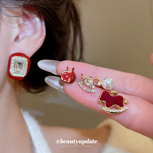 Close view of the colors and surface details on red horse pomegranate and square stud earrings