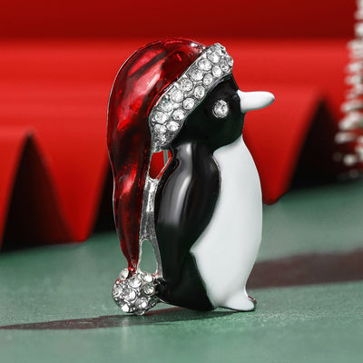 Front view of a black and white penguin wearing a red crystal-trimmed Santa hat