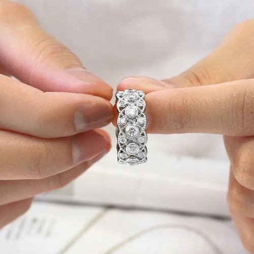 Silver lattice band ring held between fingertips