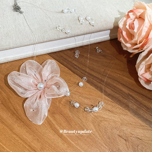 Close view of pink organza flower with pale beads, pearls, and delicate branches