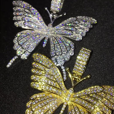Gold and silver pavé butterfly pendants stacked close-up on black