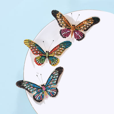 Front view of stained glass style butterfly brooch in three colorways