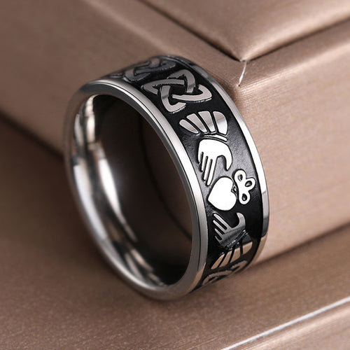 Steel Claddagh Celtic knot ring leaning on beige box close-up