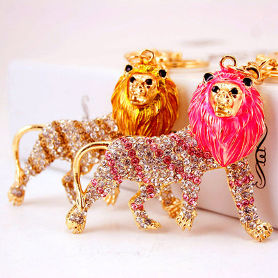 Pink and gold lion keychains with rhinestone-covered bodies displayed together.