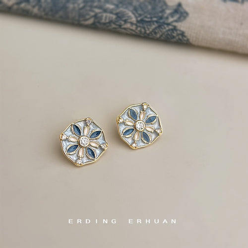 Gold blue cream enamel hexagon floral studs on beige surface