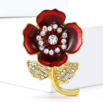 Red Poppy brooch styles arranged on a light display