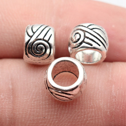 Swirl Pattern Round Large Hole Spacer Bead displayed on a natural textured background