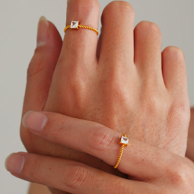 Styled hand view of gold tone twisted square solitaire ring in main image 1.