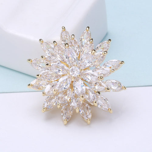 Angled display of the layered snowflake brooch on a white surface