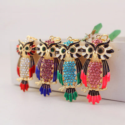 Four colorful rhinestone owl designs are displayed together in a row.