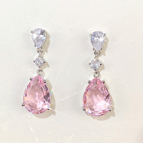 Product view showing silver-tone pink pear-shaped three-stone long drop earrings