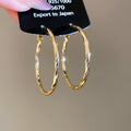 Gold Tone Twisted Oval Hoop Earrings with Detailed Finish view 6