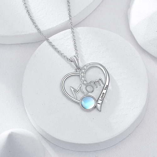 Angled detail view of silver tone mom heart pendant necklace with blue round stone