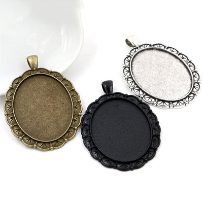 Overview of oval floral edge cabochon pendant trays in three finishes arranged on white