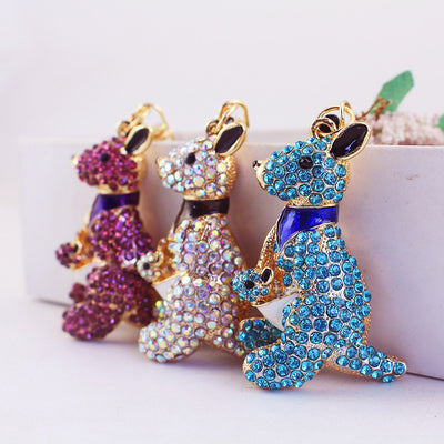 Three kangaroo and joey charms in blue, iridescent, and purple rhinestones stand together.