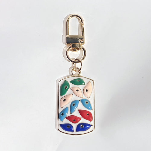 White base multicolor eye enamel dog tag keychain close-up