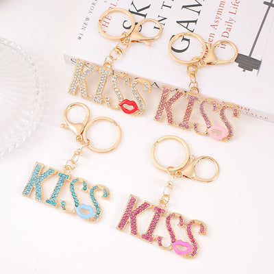 Four rhinestone KISS letter keychains in clear pink blue and rose colors