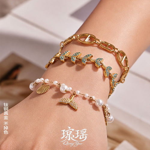On-wrist view of marine charm bracelet collection in main image 1.