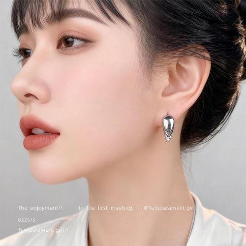 Silver-tone polished open heart chunky hoop earrings shown worn on an ear.