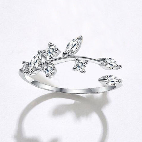Worn scale view of silver tone floral leaf open ring with clear stone accents