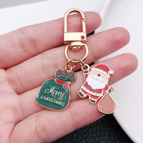 Alternate arrangement of the santa gift sack and green Christmas tag metal clasp keychain showing its hardware and charm