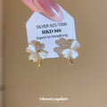 White Five-Petal Flower Stud Earrings with Polished Metal Details view 2