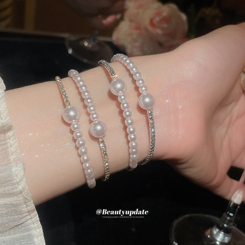 Silver and gold double pearl rhinestone cuffs stacked on wrist