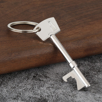 A silver-tone key-shaped opener rests diagonally on a wooden surface.