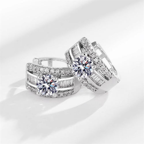Angled pair of huggie hoop earrings showing baguette channels and pavé edges
