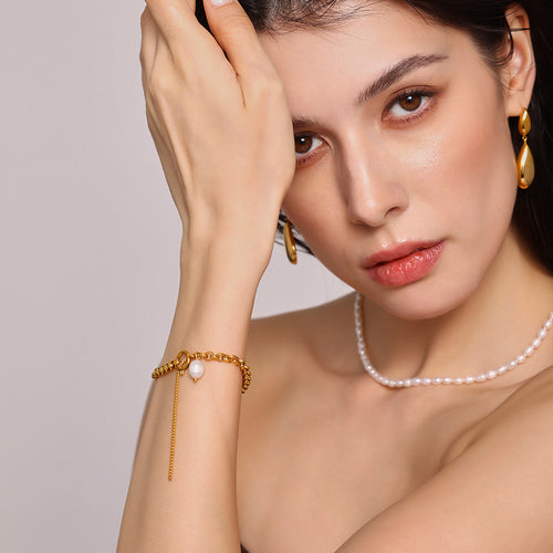 Close portrait of gold pearl toggle bracelet on model wrist