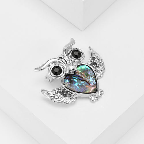 Owl brooch three-quarter view showing black eyes and shell