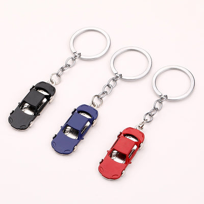 Three metal car keychains in black, blue, and red with silver-tone rings
