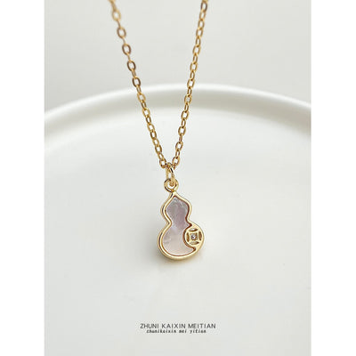 Gold-tone white inlay gourd pendant necklace on a white plate.