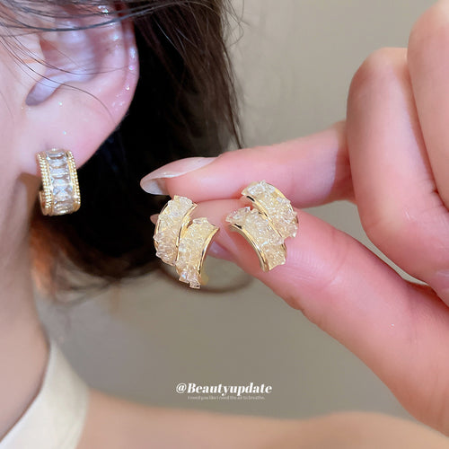 Close display of the gold rectangular crystal huggie earrings fashion jewelry accessory