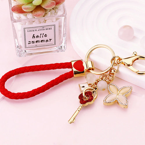 A second supplied view shows another pictured color or design of the mixed clover charm keychain.