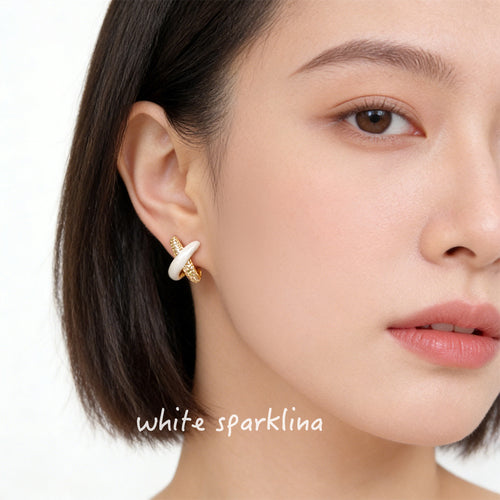 Gold cross white enamel stud worn on ear close-up