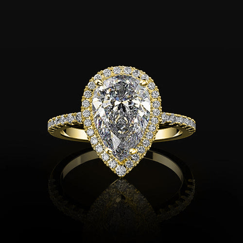 Gold-tone pear-shaped clear halo ring on black