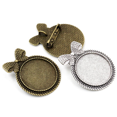 Bow Shaped Round Brooch Bezel Settings in Two Finishes assortment on a plain background