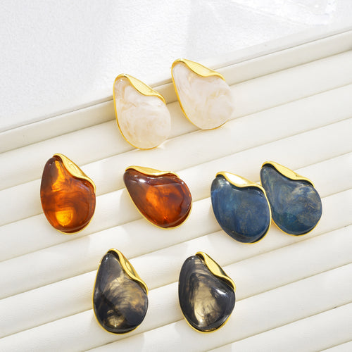 Irregular resin teardrop earrings grouped with gold-tone caps