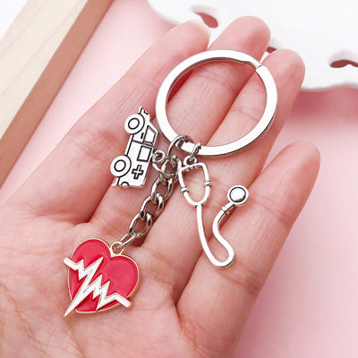 Image 1 showing a hand holding a pair of scissors and a heart shaped keychain.