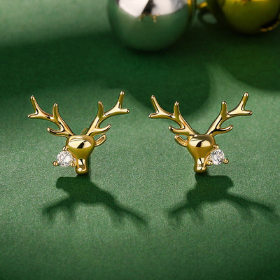 Gold deer head stud earrings with CZ on green surface and ornaments