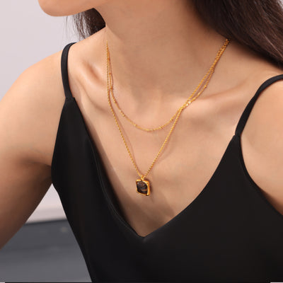 Layered gold tiger eye pendant and bead chain on model
