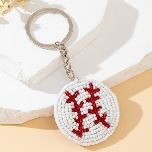 White and red beaded baseball stitch keychain shown at a different angle on marble