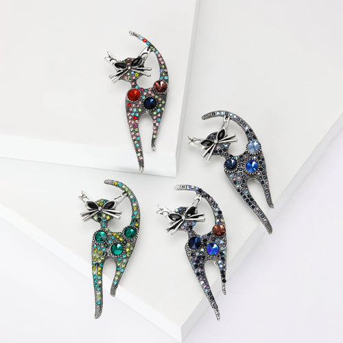 Four color cat brooches arranged on white blocks