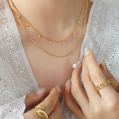 Model wearing gold double-layer rhombus charm necklace with rings