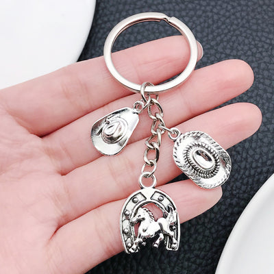 Main display of silver tone cowboy hat boot horse and cactus keychains
