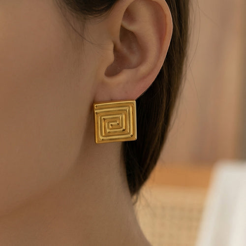 On-ear view of square Greek key stud earrings in main image 2.