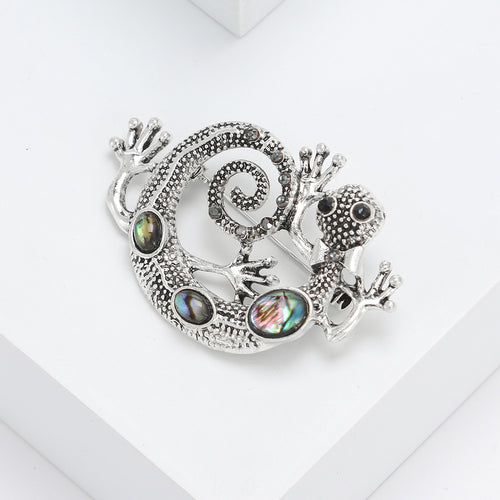 Close-up product view showing the colors and surface details of the silver tone curled lizard brooch