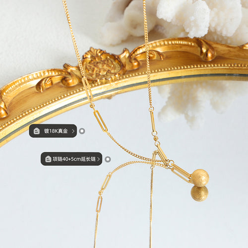 Gold frosted ball necklaces on mirror with plating and length labels