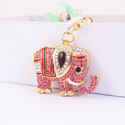 Close-up of a pink rhinestone elephant with a raised trunk and gold-tone clasp.
